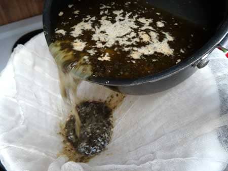 Pour weed butter mixture through the cheesecloth to strain out all the plant matter